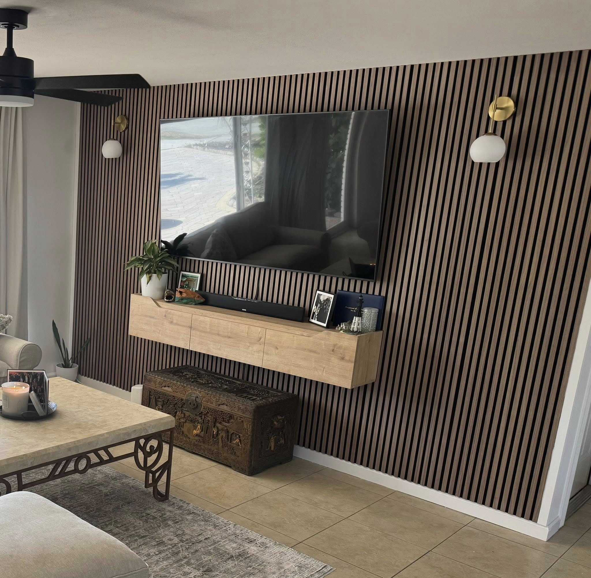 Built-in media wall with vertical wood slat backing and mounted TV
